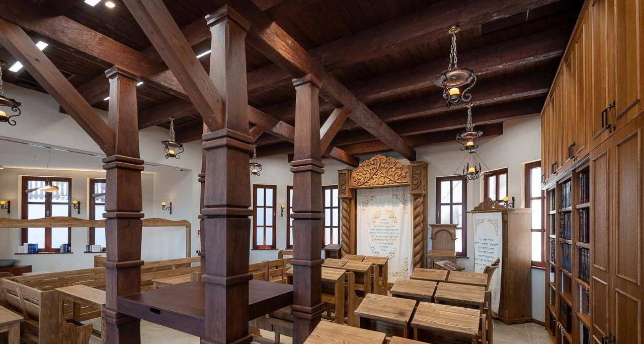 Restored bimah with wooden columns and exposed ceiling beams in the Baal Shem Tov's synagogue