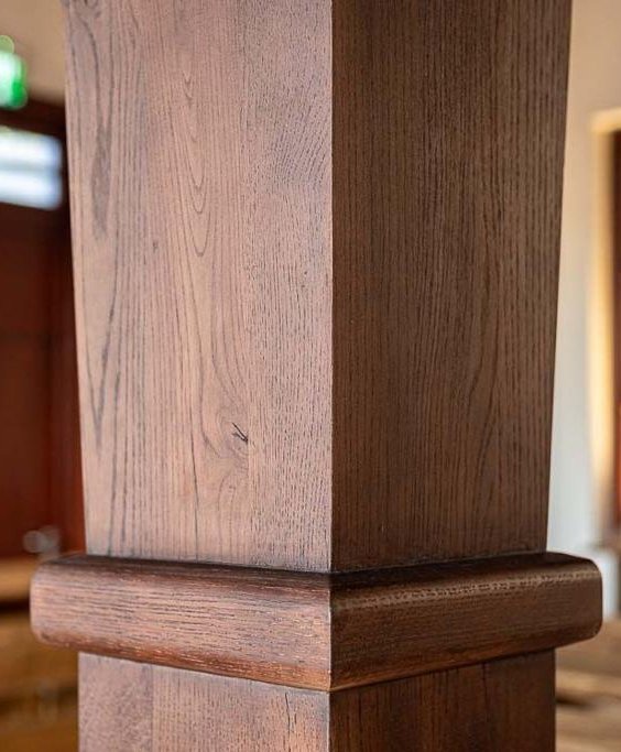 Close-up detail of a second restored wooden column at the bimah