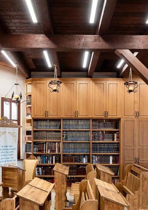 Restored interior of the Baal Shem Tov's synagogue in Medzhybizh, Ukraine, with wooden bookcases and pews